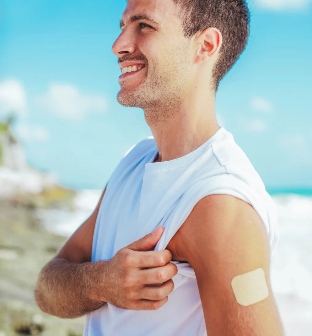 Fit man smiling on the beach wearing pain relief cbd patch